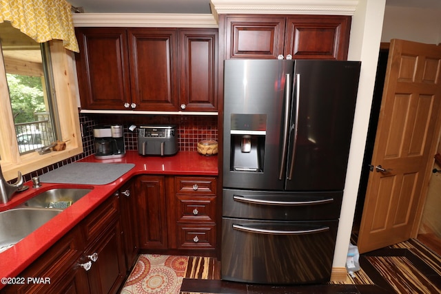 kitchen with decorative backsplash, stainless steel fridge, and sink