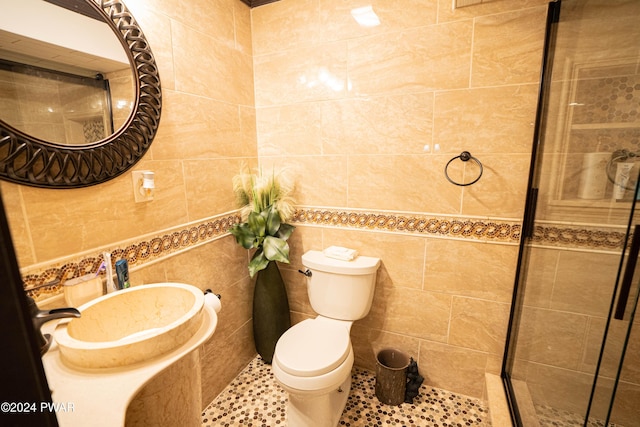 bathroom featuring sink, toilet, tile walls, and tile patterned floors