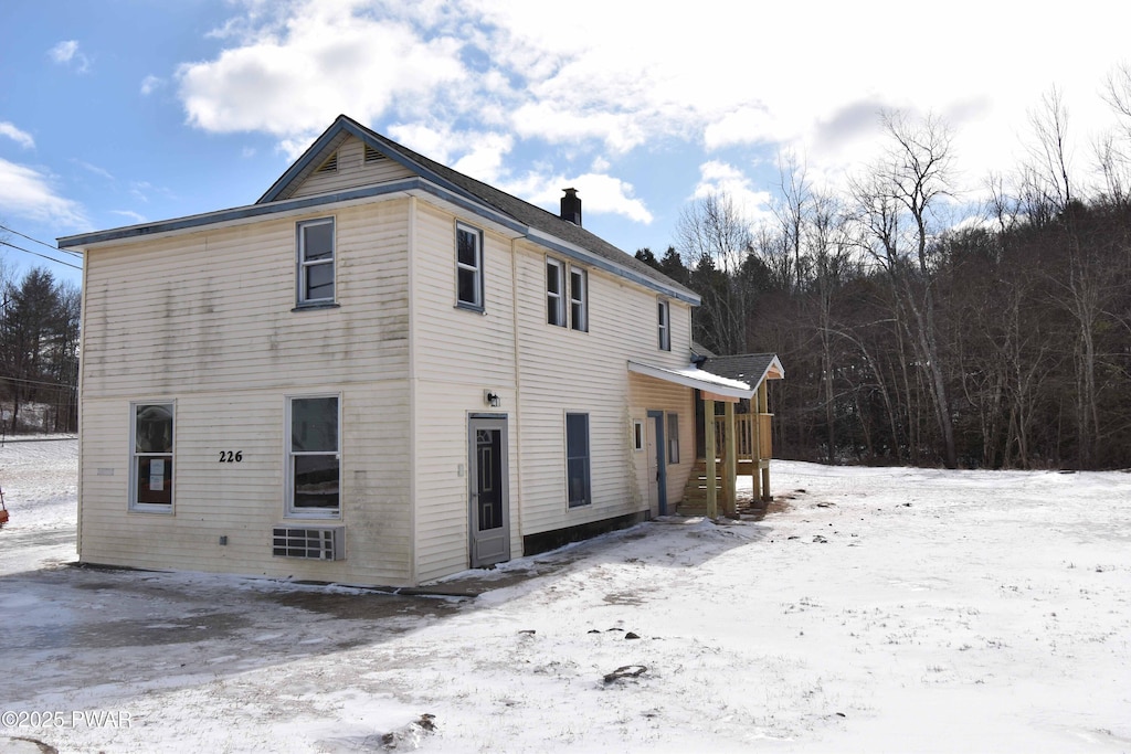 snow covered property featuring a chimney