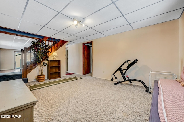 exercise room featuring carpet flooring and a paneled ceiling