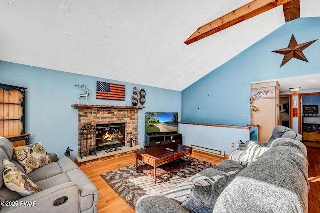 living room with vaulted ceiling with beams, hardwood / wood-style floors, a baseboard heating unit, a textured ceiling, and a brick fireplace