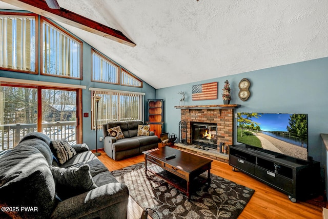 living room with vaulted ceiling with beams, hardwood / wood-style floors, and a textured ceiling