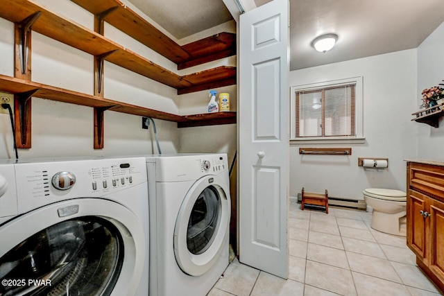 washroom with a baseboard radiator, washer and dryer, and light tile patterned floors