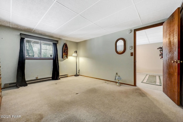 unfurnished room featuring carpet flooring, a paneled ceiling, and baseboard heating