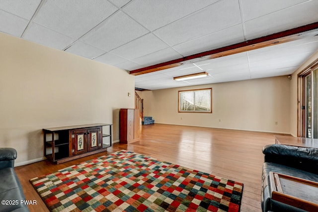 living room featuring hardwood / wood-style flooring and a paneled ceiling