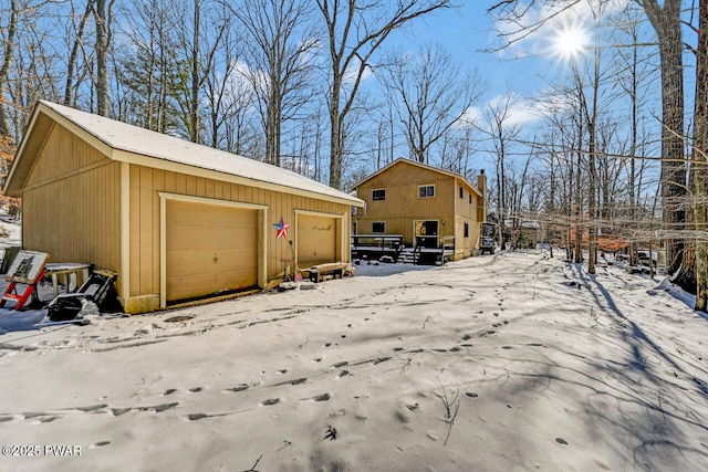 exterior space with a garage and an outbuilding