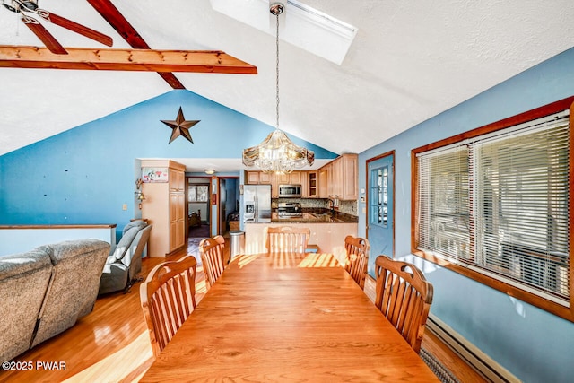 dining room with ceiling fan with notable chandelier, lofted ceiling with beams, a baseboard heating unit, a textured ceiling, and light hardwood / wood-style flooring