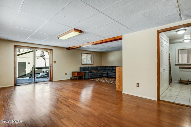 unfurnished living room with a paneled ceiling and hardwood / wood-style floors