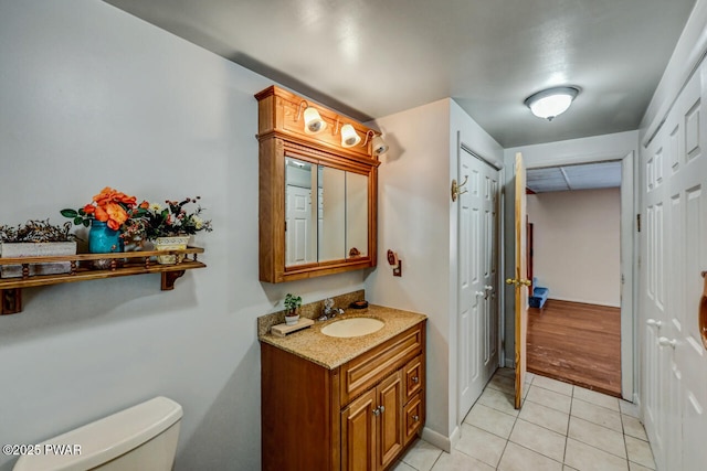 bathroom featuring tile patterned flooring, vanity, and toilet