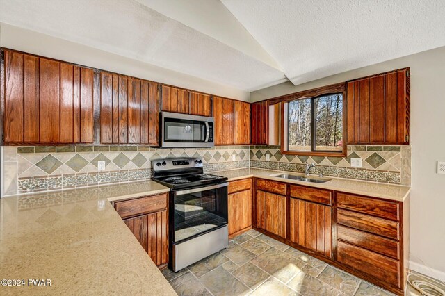 kitchen featuring sink, stainless steel appliances, and vaulted ceiling