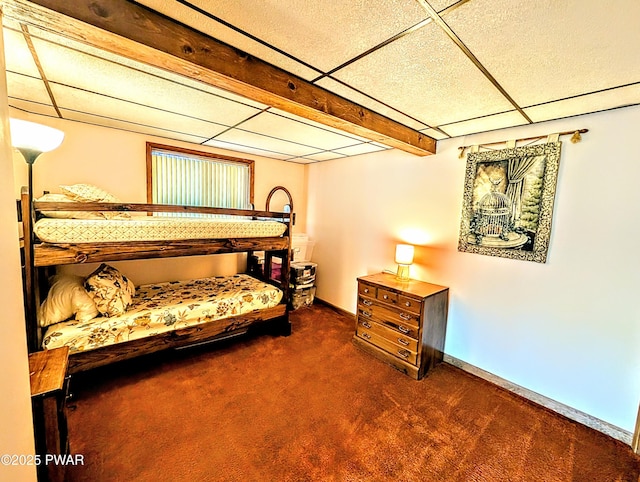 carpeted bedroom with baseboards and a drop ceiling