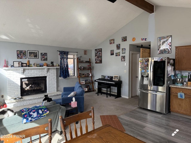 living room featuring hardwood / wood-style floors, lofted ceiling with beams, and a brick fireplace