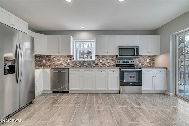 kitchen featuring white cabinets, stainless steel appliances, a wealth of natural light, and sink