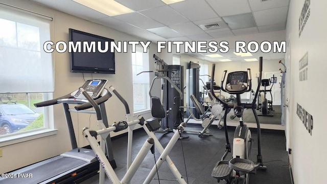 workout area featuring a paneled ceiling and a wealth of natural light