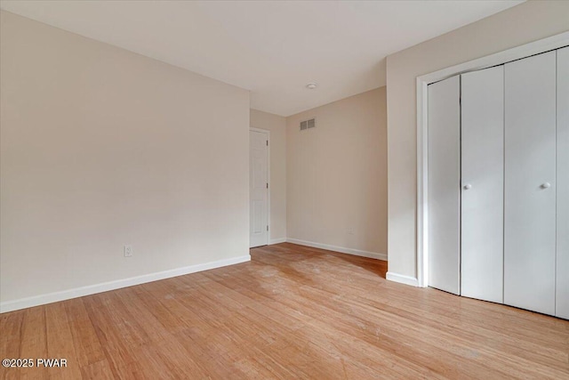 unfurnished bedroom with light hardwood / wood-style floors and a closet