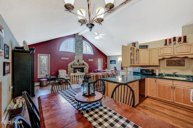 dining area featuring lofted ceiling with beams, a baseboard radiator, light wood-type flooring, a fireplace, and ceiling fan with notable chandelier