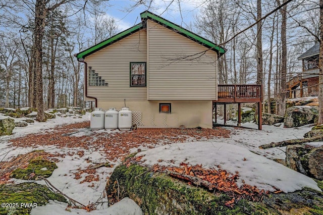 snow covered property featuring a wooden deck