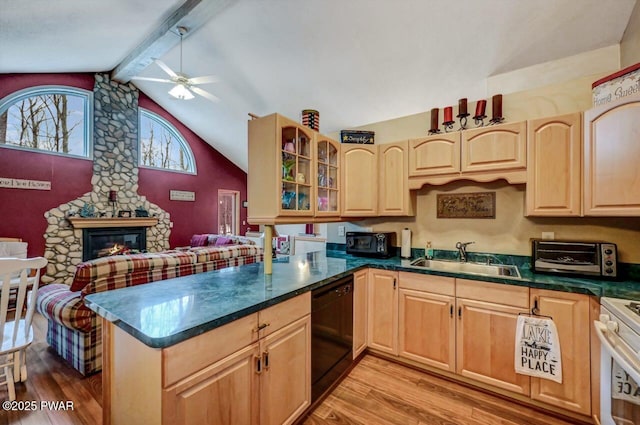 kitchen featuring dark countertops, black appliances, a peninsula, and a sink