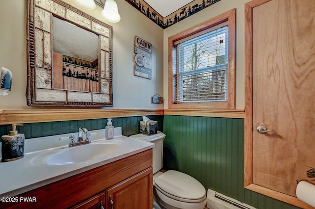 bathroom featuring toilet, a baseboard radiator, vanity, and wainscoting