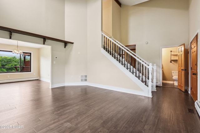198 State Route 690, Springbrook Township, PA 18444 - unfurnished living room featuring a high ceiling, a baseboard radiator, a chandelier, stairs, and dark wood-type flooring