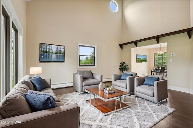 198 State Route 690, Springbrook Township, PA 18444 - living room featuring a baseboard radiator, a high ceiling, wood finished floors, and a chandelier