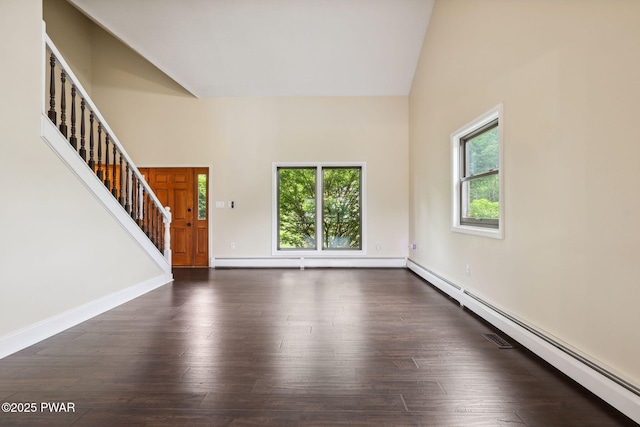 198 State Route 690, Springbrook Township, PA 18444 - unfurnished living room featuring baseboard heating, plenty of natural light, stairway, dark wood-type flooring, and high vaulted ceiling