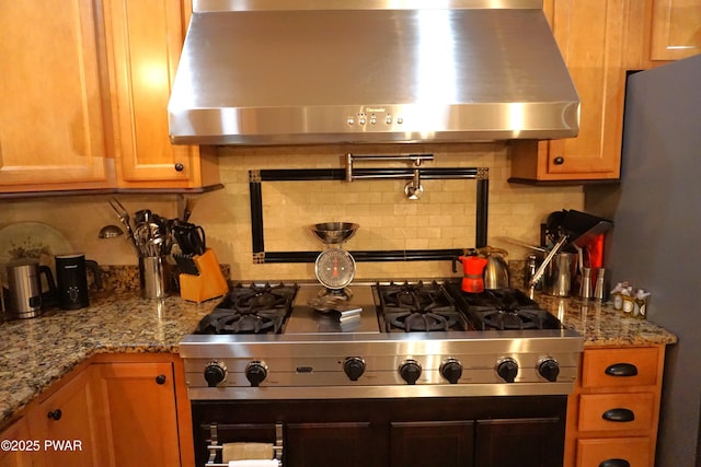 103 Valley Forge Rd, Milford, PA 18337 - kitchen with wall chimney range hood, decorative backsplash, brown cabinets, and light stone counters