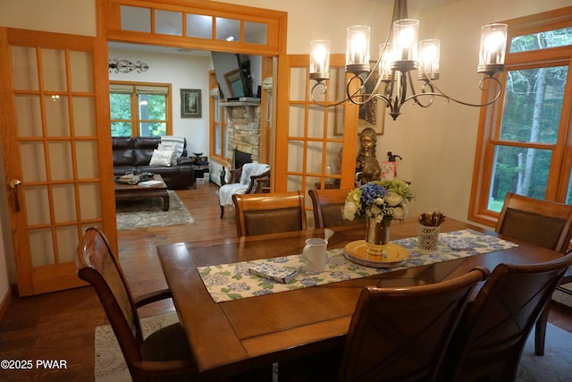 103 Valley Forge Rd, Milford, PA 18337 - dining room with wood finished floors, a chandelier, and a stone fireplace