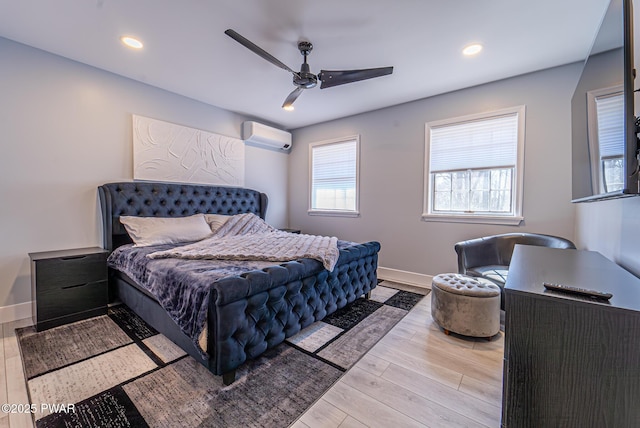 bedroom with a wall mounted AC, recessed lighting, wood finished floors, and baseboards