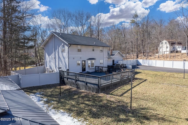 rear view of house featuring a fenced backyard, a wooden deck, and a yard