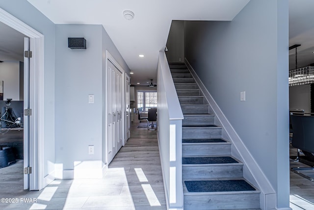 stairs featuring ceiling fan, wood finished floors, and recessed lighting