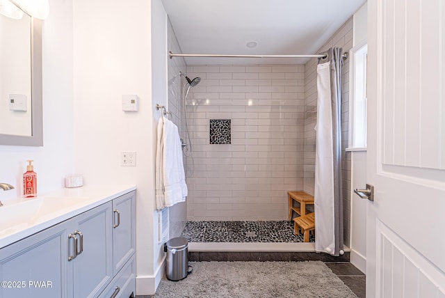 full bathroom with tile patterned floors, tiled shower, and vanity