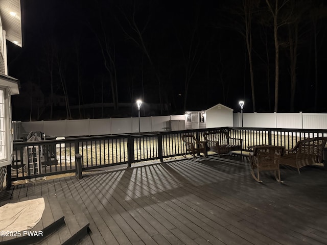 deck at twilight with a fenced backyard