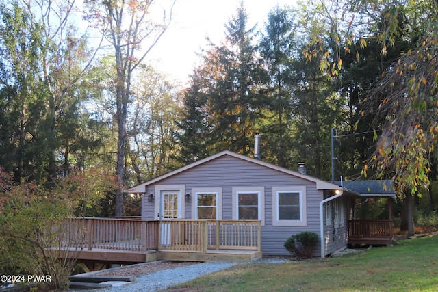 view of front of property featuring a front lawn and a wooden deck