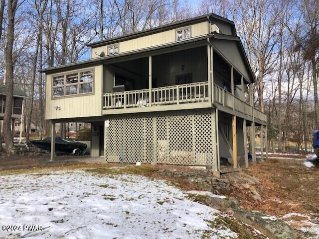 view of snow covered back of property