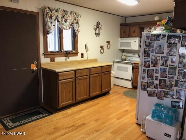 kitchen with white appliances and light hardwood / wood-style floors