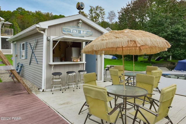 wooden terrace with a yard and an outdoor bar