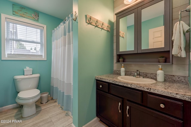 bathroom featuring a shower with shower curtain, vanity, and toilet