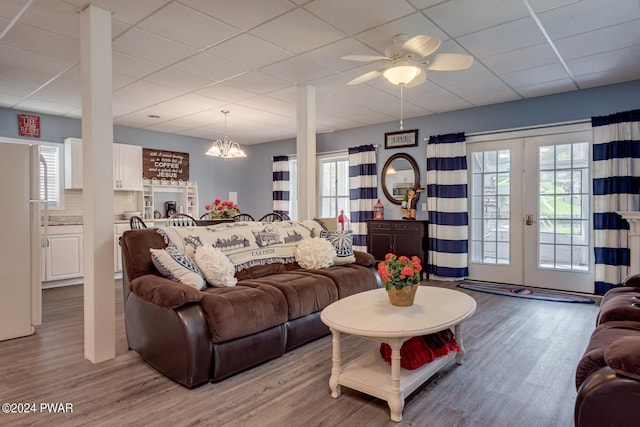 living room with a paneled ceiling, ceiling fan with notable chandelier, and light wood-type flooring