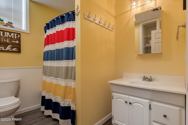 bathroom with curtained shower, hardwood / wood-style flooring, vanity, and toilet