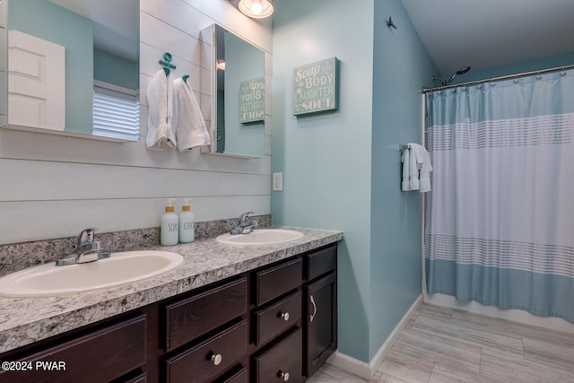 bathroom with a shower with shower curtain, vanity, and vaulted ceiling