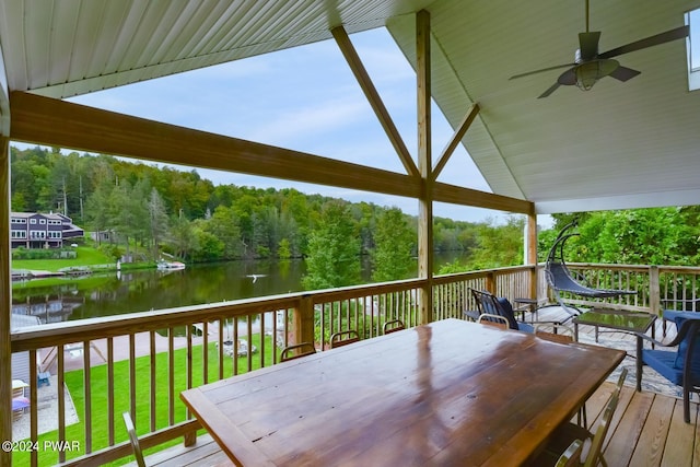 deck featuring a water view, ceiling fan, and a lawn