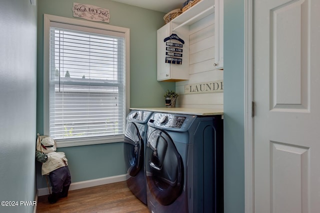 washroom with separate washer and dryer, cabinets, and light hardwood / wood-style floors