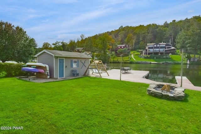 back of house with a lawn, a water view, a patio, and an outdoor structure