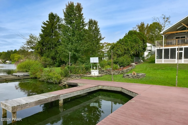 dock area featuring a lawn and a water view