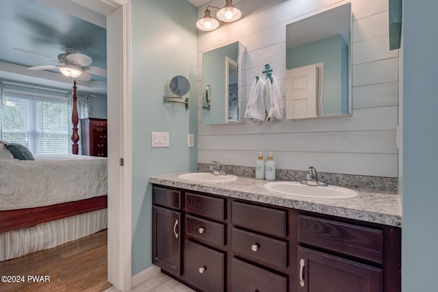 bathroom with hardwood / wood-style floors, ceiling fan, and vanity