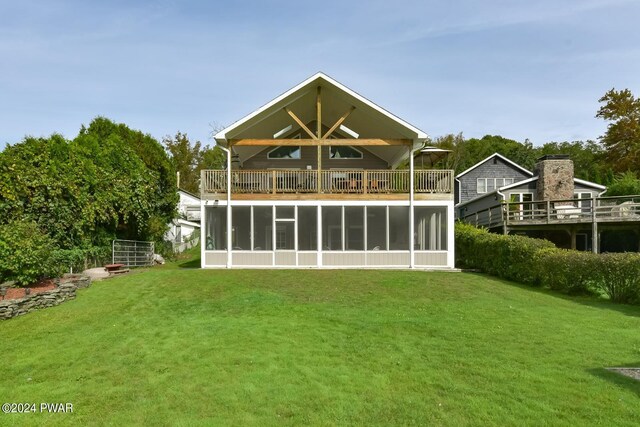 back of property with a sunroom and a yard