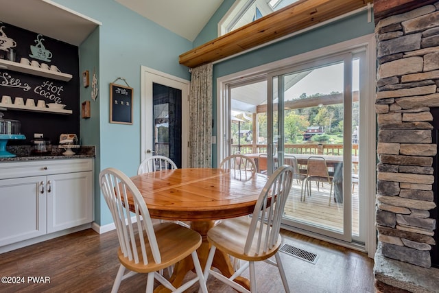 dining space with dark hardwood / wood-style flooring and lofted ceiling