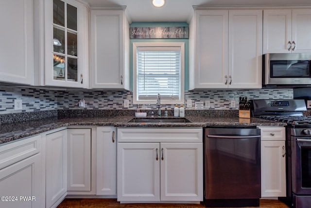 kitchen featuring dark stone countertops, white cabinetry, sink, and appliances with stainless steel finishes