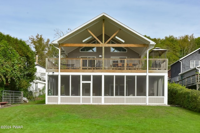 rear view of property featuring a sunroom and a yard